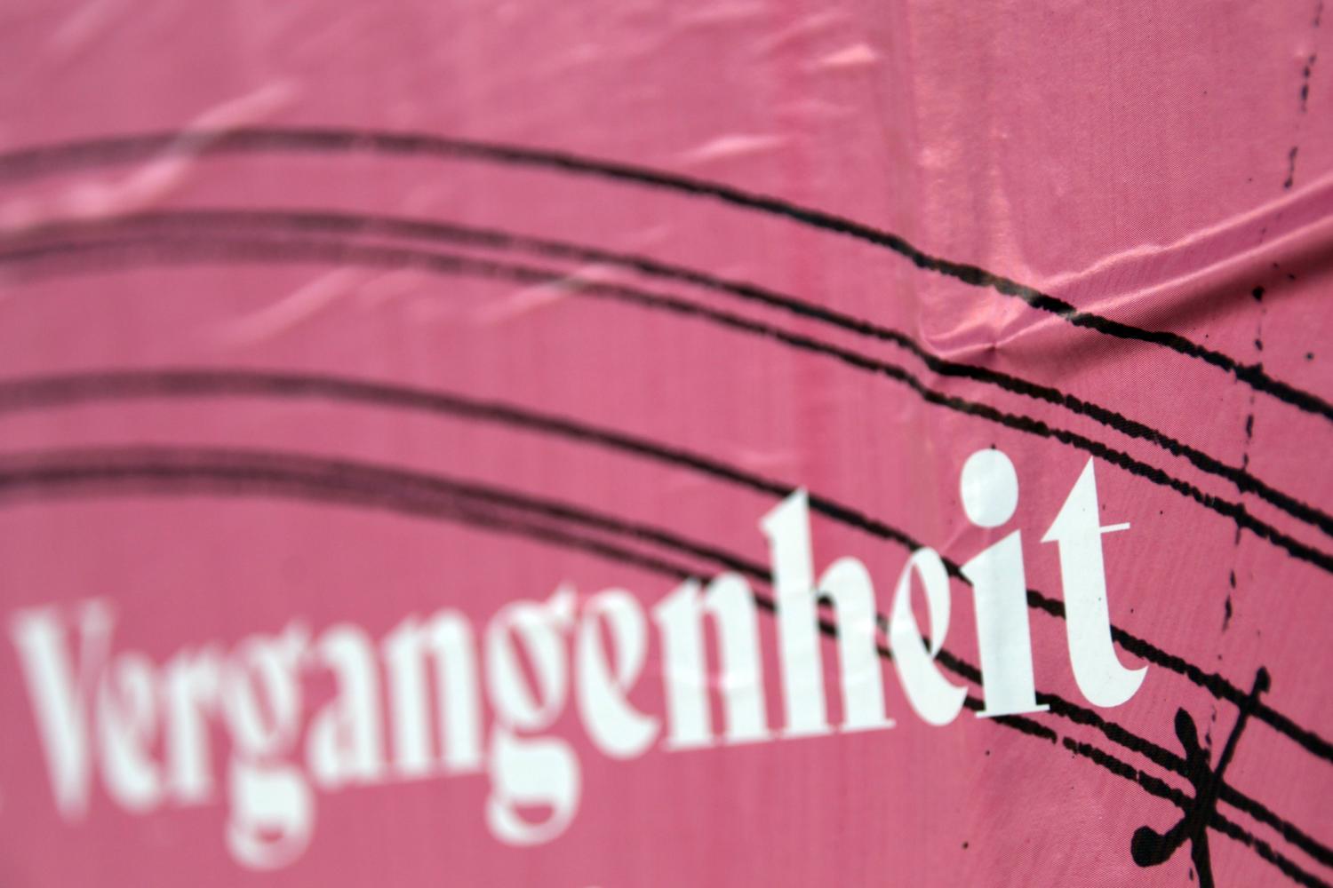 Weiße Schrift „Vergangenheit“ auf rosa Hintergrund mit schwarzen Linien